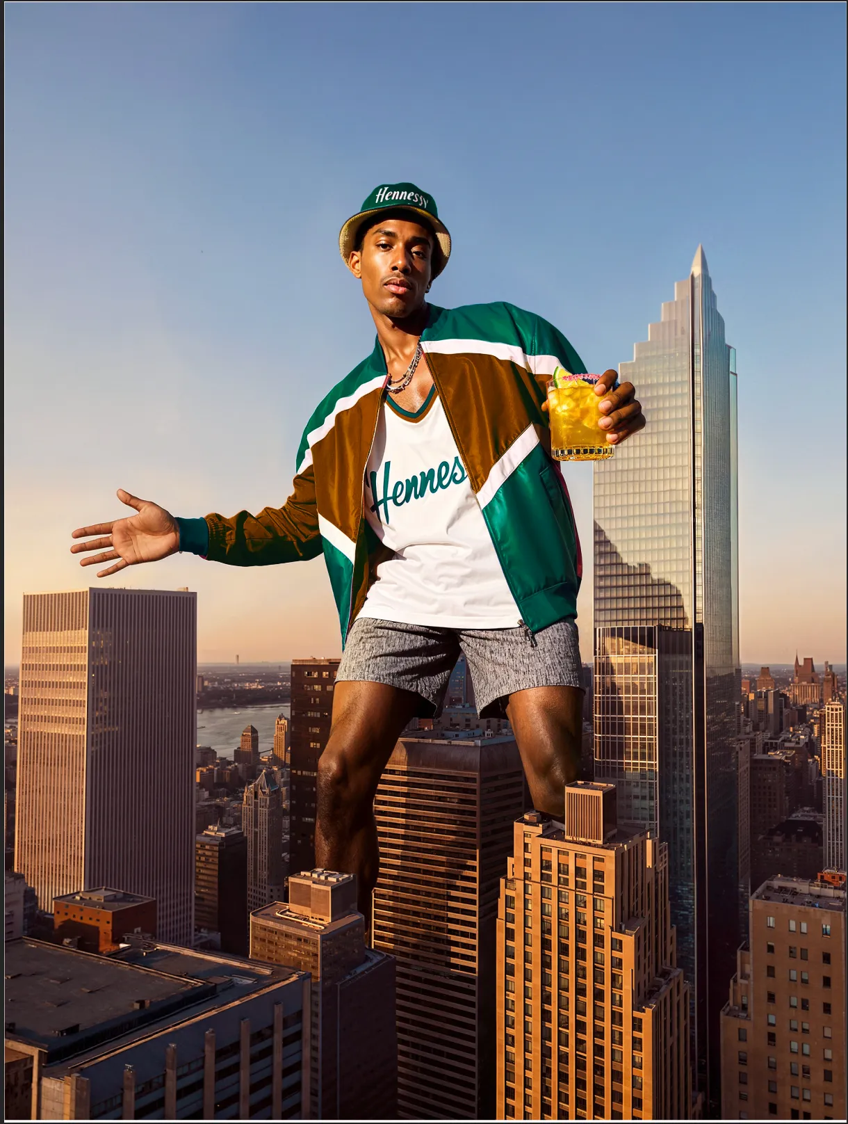 Man sitting on a rooftop ledge above a city skyline, arms raised, holding a Hennessy bottle — ai advertising agency Thinkdiff, photography & art direction by Thinkdiff AI Production House