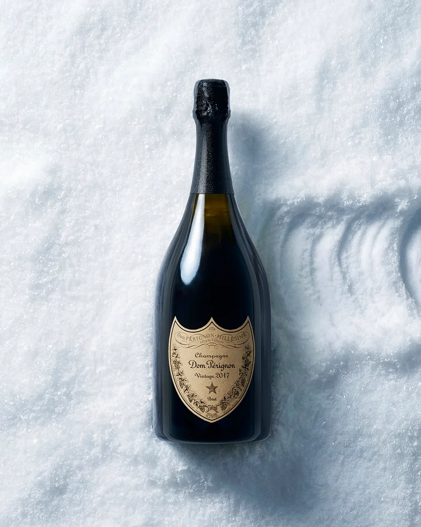 Dom Pérignon bottle standing upright in fresh snow, casting a long diagonal shadow under bright sunlight — ai video production Thinkdiff, photography & art direction by Pierrick Jégou, produced by Thinkdiff AI Production House