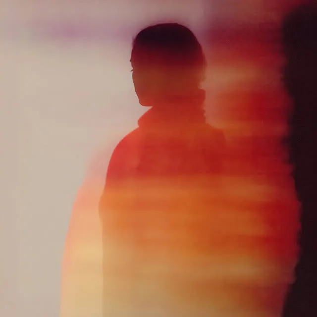 Abstract silhouette of a person in warm orange and red horizontal light streaks, motion-blurred composition — ai advertising agency Thinkdiff, generative AI artwork & art direction by Charlie Faye Mather